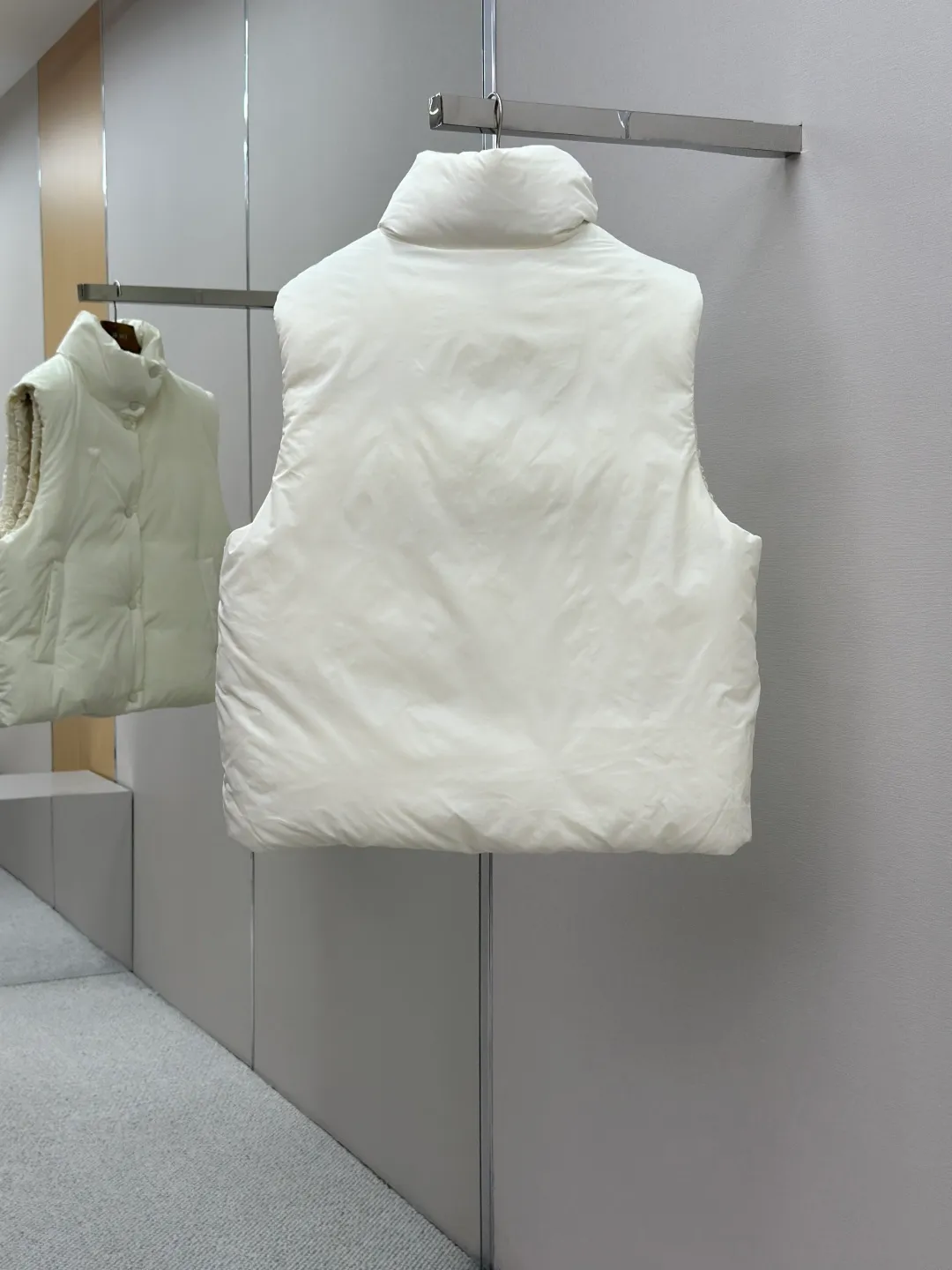 P810 AMIPARIS love padded embroidered down vest Fabric selection: Taffeta fabric woven from 100% polyester fiber. It adopts warp and weft plain weave and is woven very tightly, making the surface of the fabric extremely smooth and flat, with a "skinny" and stiffness that is not easy to collapse. When rubbed or moved around, it will make a unique, crisp "rustling" sound. At the same time, it has a delicate plain texture and a soft, elegant silky luster. This kind of luster is not as dazzling as satin, but more restrained and advanced.  Lining selection: Use 100% nylon to create the lining. The high-density and tight weaving process prevents tiny lint from getting out of the gaps in the fabric. The smooth surface improves the putting on and taking off experience, and the excellent wear and tear resistance ensures damage caused by frequent use, while the light and soft texture does not affect the overall weight.  Technology: The fabric and padding material are tightly fixed on the frame of the embroidery machine. The embroidery machine uses sparse stitches along the padding layer to outline the filling area of the pattern, and then runs the overlay layer's padding, using dense stitches to perfectly cover the foam padding layer, thus forming a slightly raised love embroidery, which feels soft and full, enhancing recognition while maintaining a low profile. High-quality filling: It uses 90 white duck down with a weight of 160g to ensure excellent thermal insulation performance. After strict screening and processing, the velvet is not easy to get drilled, ensuring durability.  Accessories: One-to-one customized three-standard, one-to-one customized hem elastic buckle, one-to-one customized snap button SIZE: XS S M L